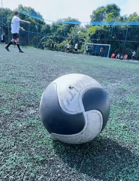 Bola de futebol em primeiro plano na quadra society da Arena Sul.